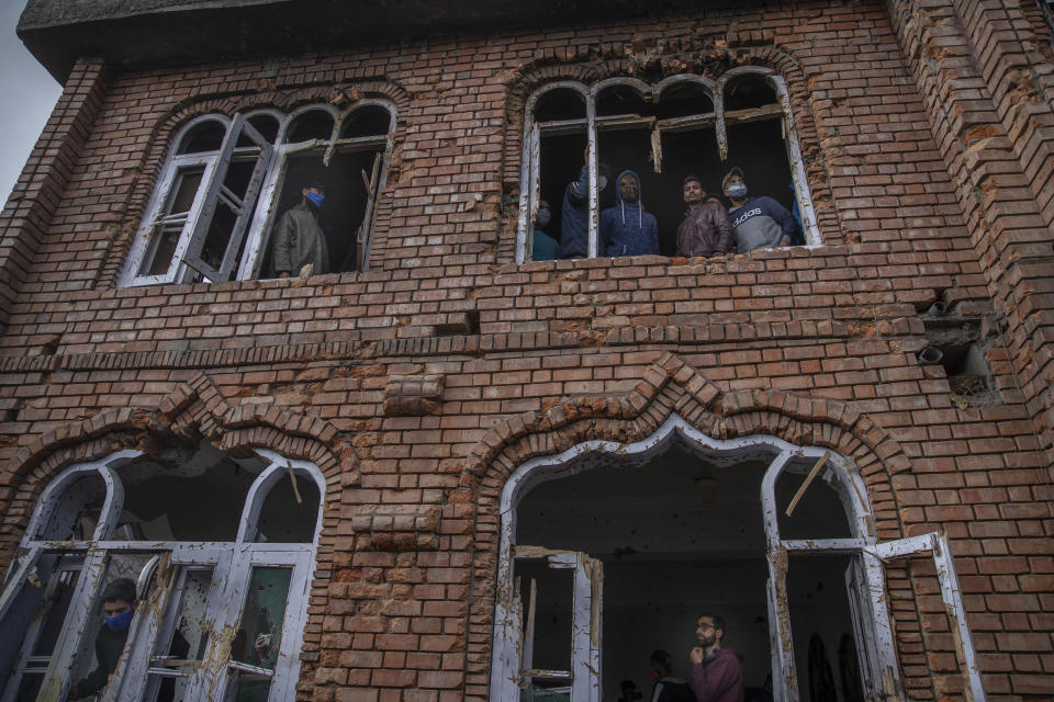 Kashmiri villagers inspect a mosque partially damaged during a gunbattle in Shopian, south of Srinagar, Indian controlled Kashmir, Friday, April 9, 2021. Seven suspected militants were killed and four soldiers wounded in two separate gunfights in Indian-controlled Kashmir, officials said Friday, triggering anti-India protests and clashes in the disputed region. (AP Photo/ Dar Yasin)