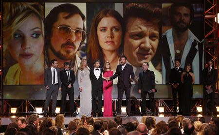 Bradley Cooper accepts the award for best acting ensemble for "American Hustle" as the cast including actors Elisabeth Rohm (3rd L), Jeremy Renner (4th L) and Amy Adams (5th L) look on during the 19th annual Critics' Choice Movie Awards in Santa Monica, California January 16, 2014. REUTERS/Mario Anzuoni