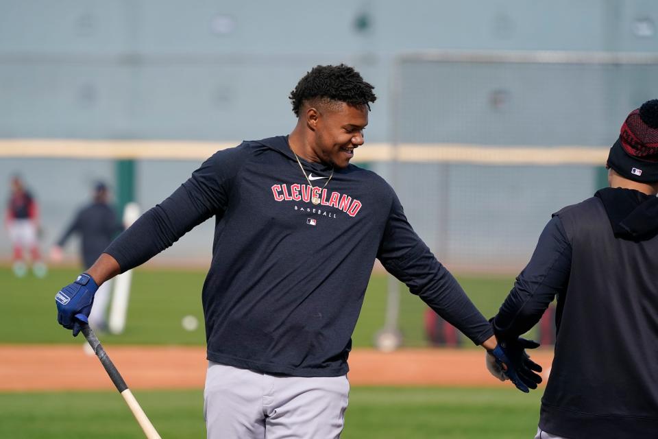 Cleveland Guardians' Oscar Gonzalez, left, smiles as he slaps hands with Guardians' Josh Naylor during batting practice on the first day of MLB spring training baseball workouts for the Guardians in Goodyear, Ariz., Friday, Feb. 17, 2023. (AP Photo/Ross D. Franklin)