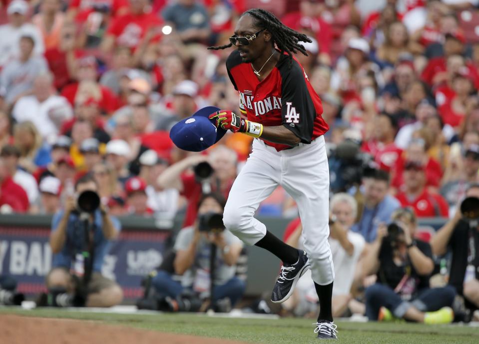 Snoop Dogg runs toward second base during the Legends and Celebrity Softball game, Sunday, July 12, 2015, at Great American Ball Park.