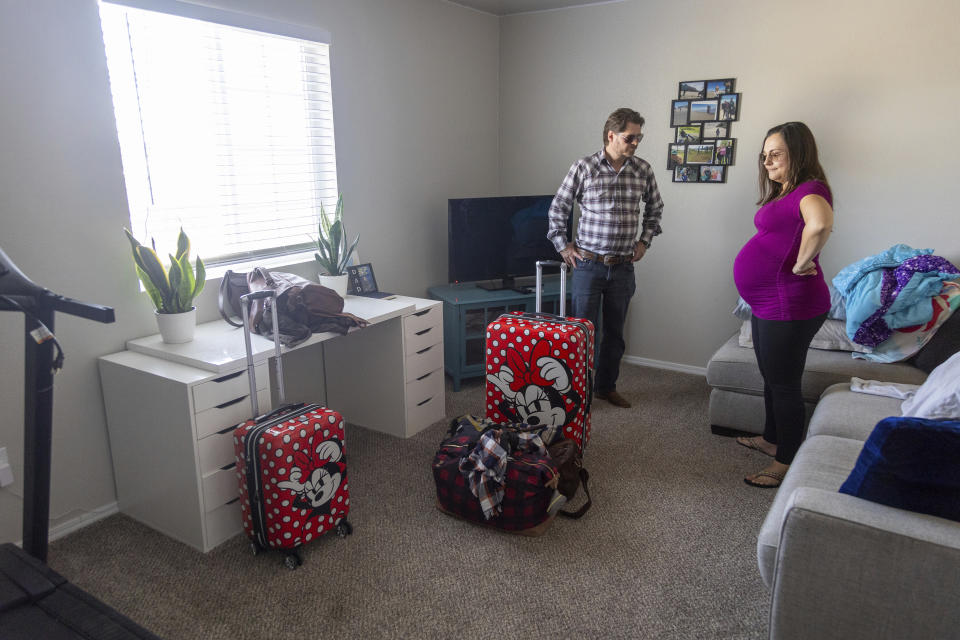 Shane and Alisha Alderson, of Baker City, Ore., carry belongings up to a spare bedroom in the home of Alisha's sister, Gina Conway, in Kuna, Ore., on Friday, Sept. 1, 2023. Women in Baker City will no longer have access to a maternity center with the closure of St. Alphonsus' obstetrical unit, the only one of its kind in Baker County. (AP Photo/Kyle Green)