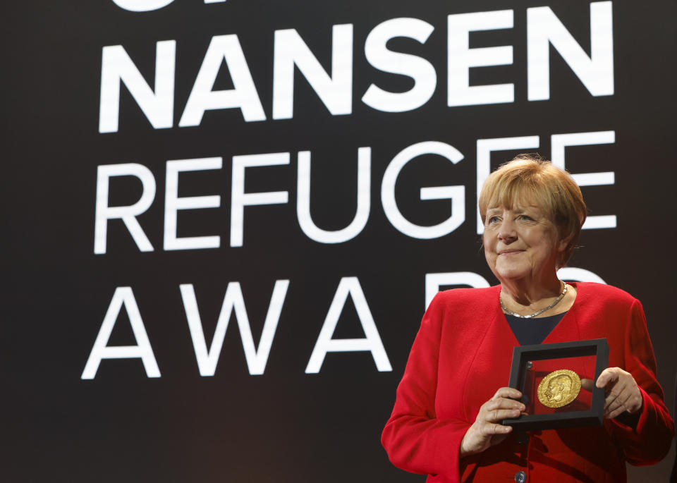 Angela Merkel poses with the UNHCR Nansen Refugee Award for protecting refugees at the height of the Syria crisis, during a ceremony in Geneva, Switzerland, Monday Oct. 10, 2022. (Stefan Wermuth/Pool via AP)