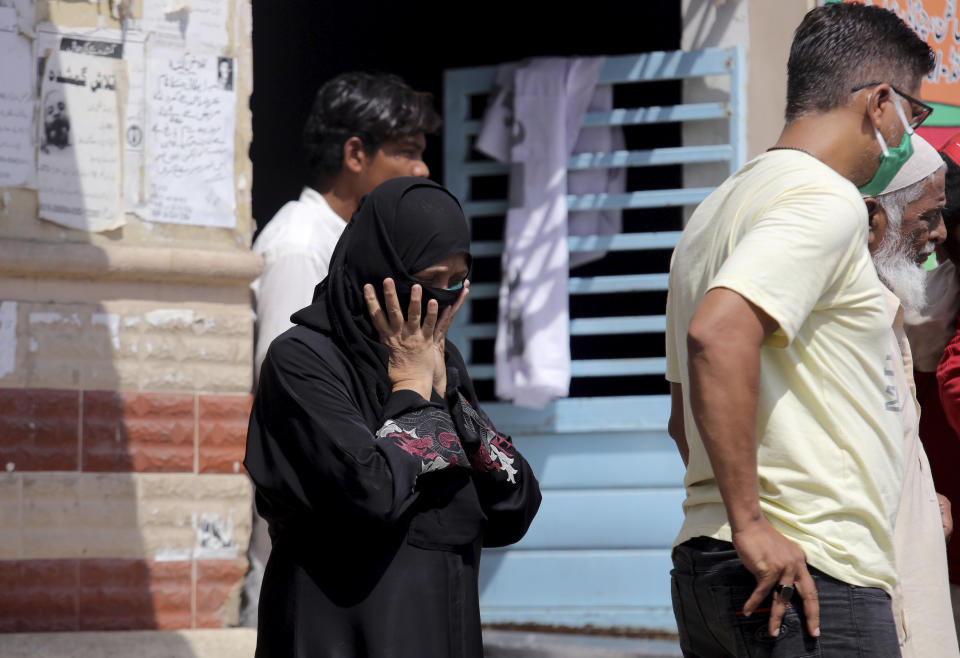 A woman arrive to identify body of her family member who was killed in the Friday's plane crash, at a morgue in Karachi, Pakistan, Saturday, May 23, 2020. An aviation official says a passenger plane belonging to state-run Pakistan International Airlines carrying passengers and crew has crashed near the southern port city of Karachi. (AP Photo/Fareed Khan)