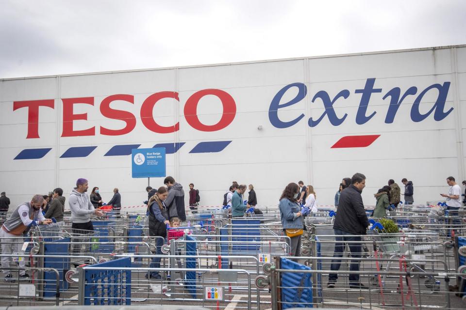 People queueing at Tesco following social distancing guidance (PA)