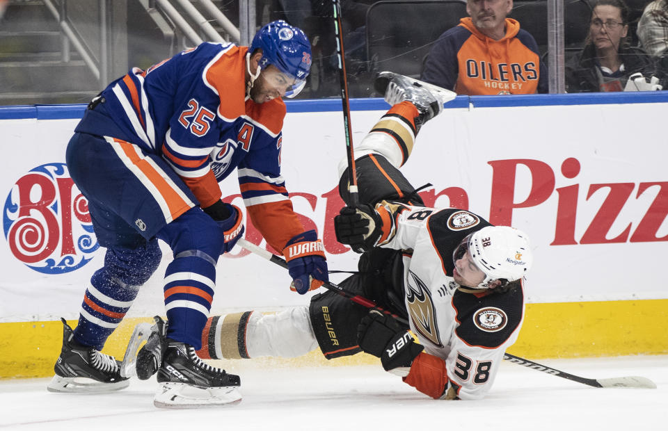 Anaheim Ducks' Derek Grant (38) is checked by Edmonton Oilers' Darnell Nurse (25) during the third period of an NHL hockey game Saturday, April 1, 2023, in Edmonton, Alberta. (Jason Franson/The Canadian Press via AP)