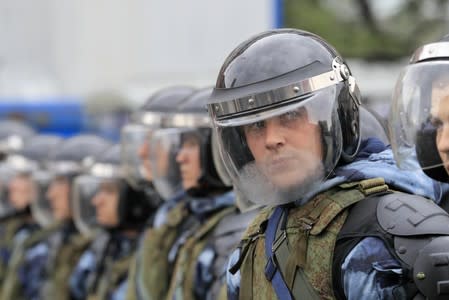 Law enforcement officers stand guard during a rally to demand authorities allow opposition candidates to run in a local election in Moscow