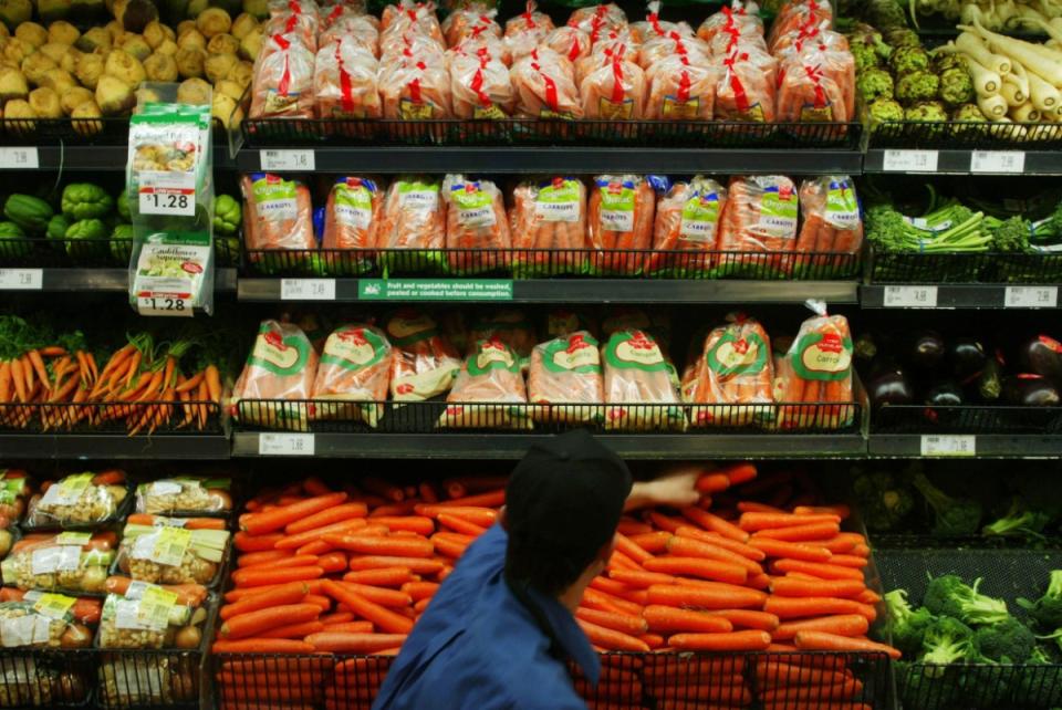 Coles worker at fresh produce shelves