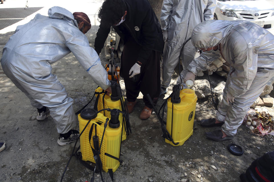 Volunteers in protective suits prepare disinfectant to spray on passing vehicles to help curb the spread of the coronavirus in Kabul, Afghanistan, Sunday, May 3, 2020. (AP Photo/Rahmat Gul)