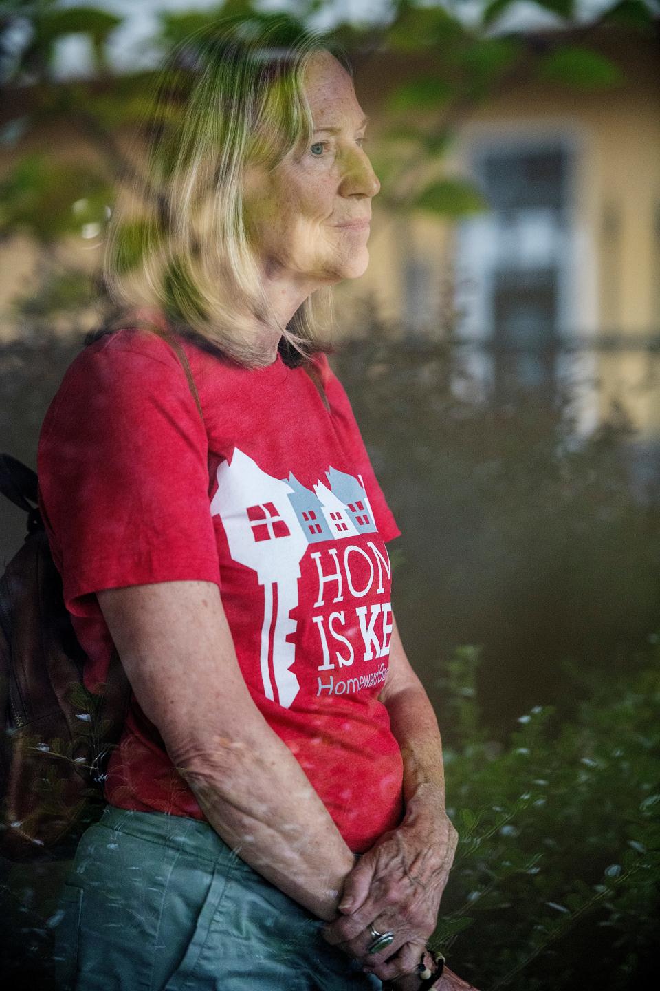 The Days Inn is reflected in a window as Eleanor Ashton stands inside one of the motel's 85 rooms which will be transformed into efficiency apartments for the chronically homeless.