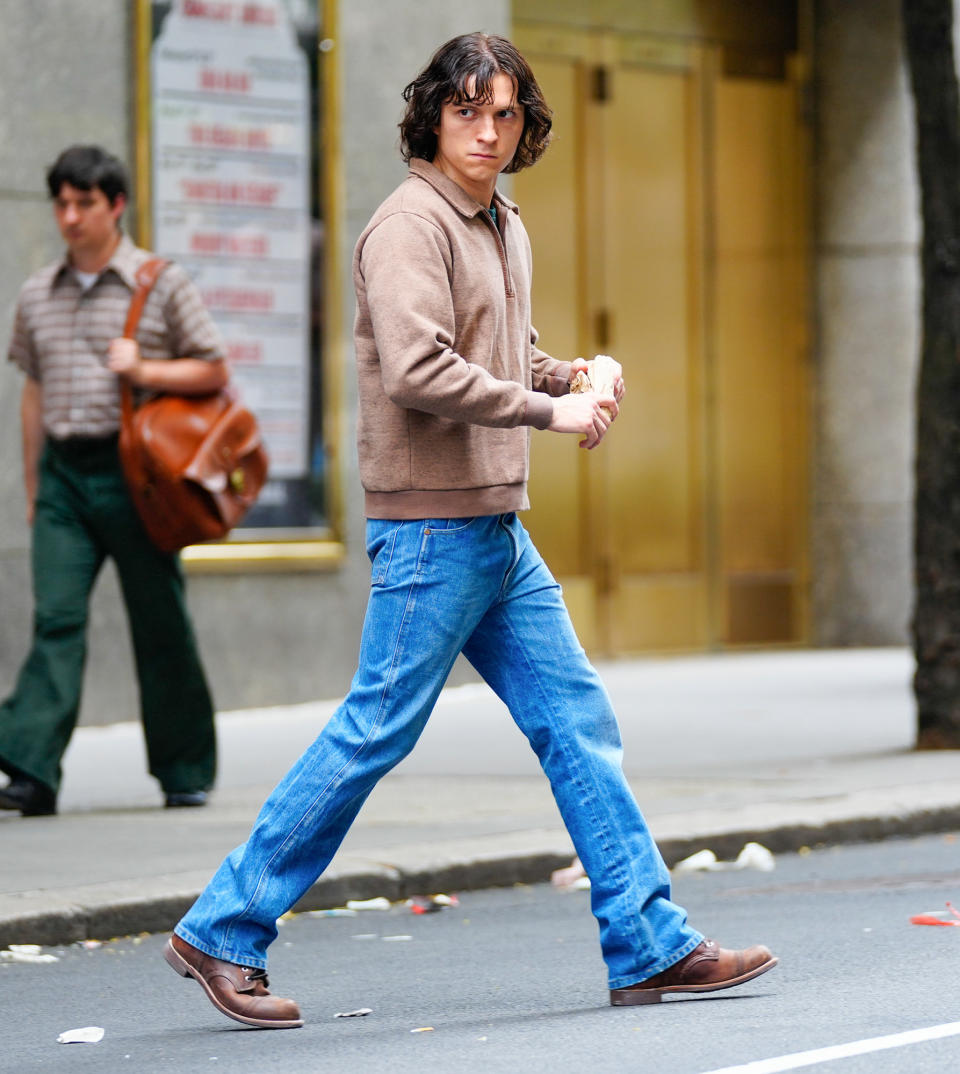 <p>Tom Holland crosses the street outside Radio City Music Hall in N.Y.C. on July 5 while filming scenes for <em>The Crowded Room.</em></p>