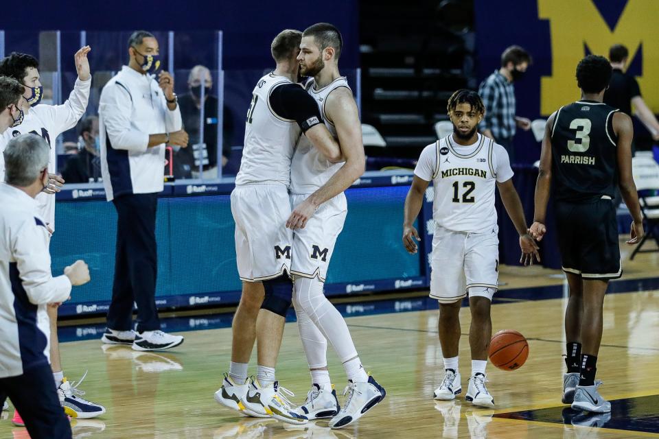 Michigan forward Austin Davis (51) celebrate with center Hunter Dickinson (1) after 81-71 win over Oakland in overtime at the Crisler Center in Ann Arbor, Sunday, Nov. 29, 2020.