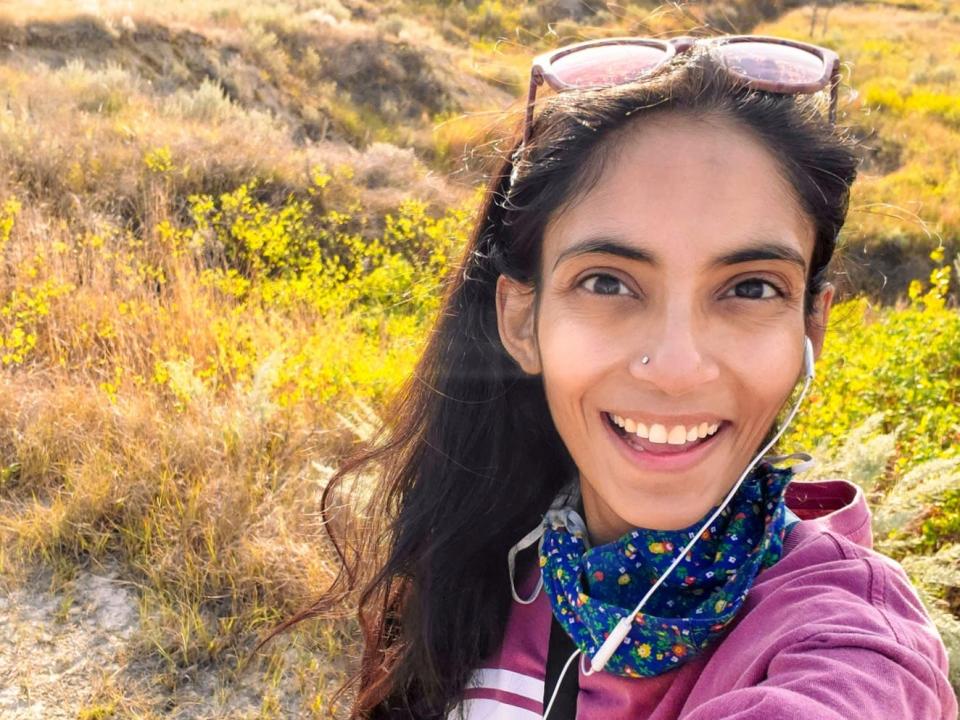 Alka Bhatt wearing sunglasses on her head and smiling in a desert.