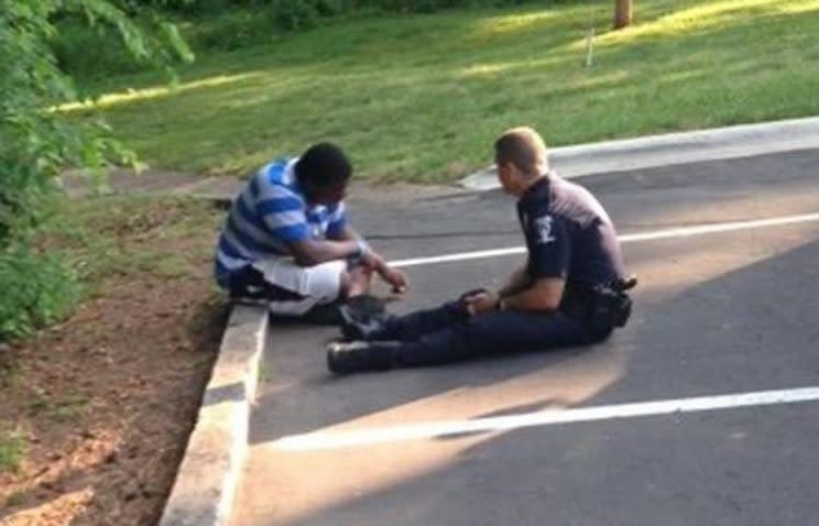 Officer Tim Purdy of the Charlotte-Mecklenberg Police Department received widespread praise when a photo surfaced of him talking with a special needs teen on the ground in a parking lot. (Charlotte-Mecklenburg Police Department/Facebook) 