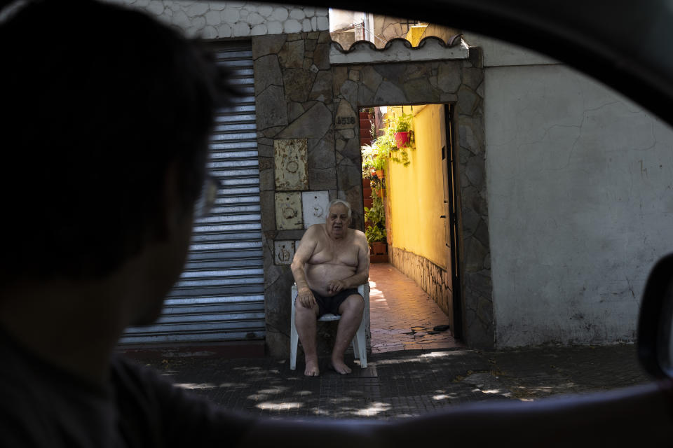 A man cools off on his doorstep in Las Heras, the neighborhood where soccer player Lionel Messi lived in Rosario, Argentina, Wednesday, Dec. 14, 2022. (AP Photo/Rodrigo Abd)