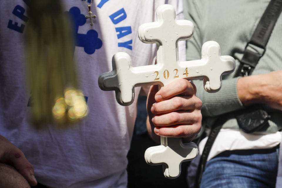 John Hittos, 16, holds the cross that he retrieved as he is blessed during the annual cross dive in the Spring Bayou, part of the Epiphany celebration on Saturday, Jan. 6, 2024, in Tarpon Springs, Fla. (Jefferee Woo/Tampa Bay Times via AP)