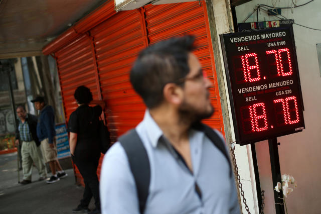 A man walksin front of a board displaying the exchange rate for Mexican Peso and U.S. Dollar at a foreign exchange house in Mexico City, Mexico September 4, 2019. REUTERS/Edgard Garrido