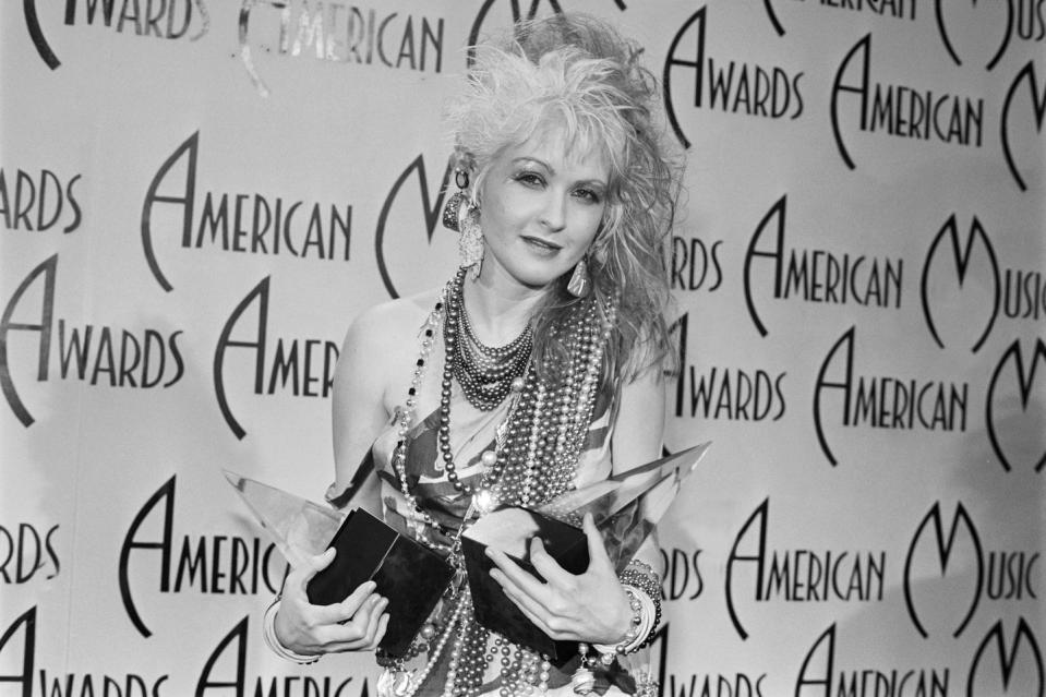 pop star cyndi lauper holds her two american music awards, which she won for favorite female artist poprock and favorite female video artist poprock