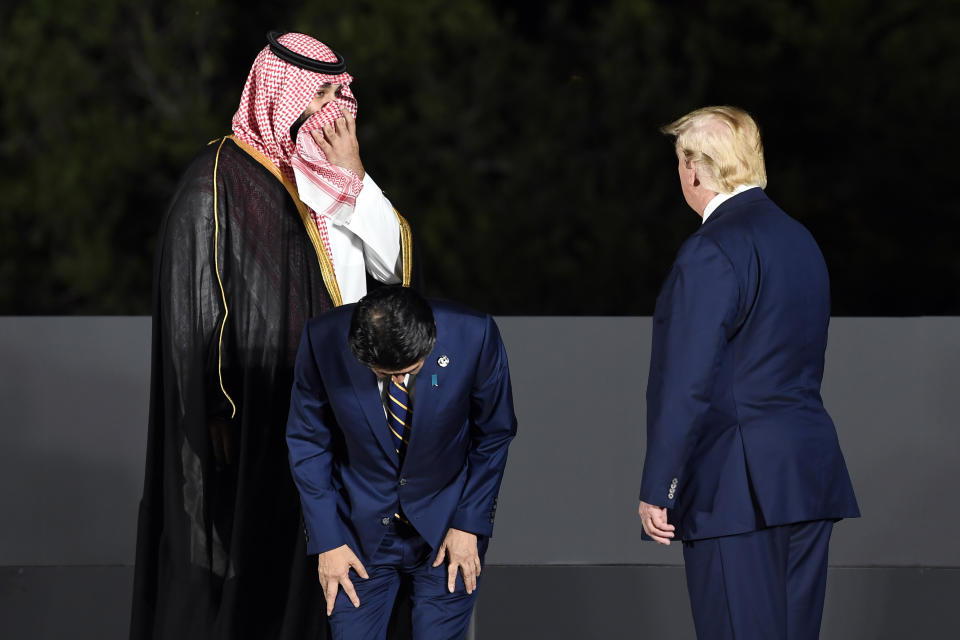 Saudi Prince Mohammed bin Salman, left, look towards President Donald Trump, right, as Japanese Prime Minister Shinzo Abe, center, looks down as they and other leaders and guests begin to gather for a group photo as part of the G-20 summit cultural event at Osaka Castle in Osaka, Japan, Friday, June 28, 2019. (AP Photo/Susan Walsh)