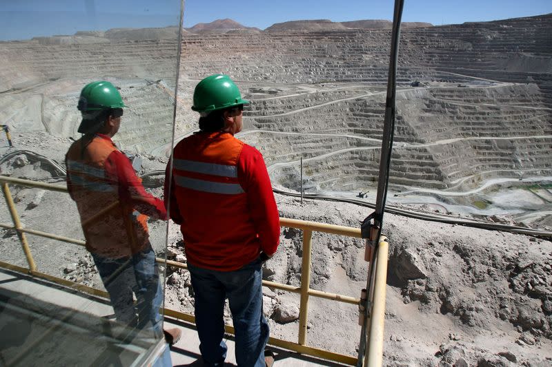 FILE PHOTO: Workers at BHP Billiton's Escondida, the world's biggest copper mine, are seen in front of the open pit, in Antofagasta,
