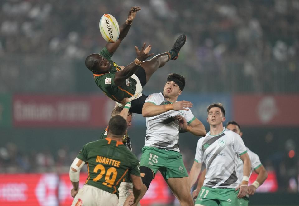 South Africa's Siviwe Sonwabile, top, tries to catch the ball as Ireland's Aaron O'Sullivan defends, during the final match of the Emirates Airline Rugby Sevens, in Dubai, United Arab Emirates, Saturday, Dec. 3, 2022. (AP Photo/Kamran Jebreili)