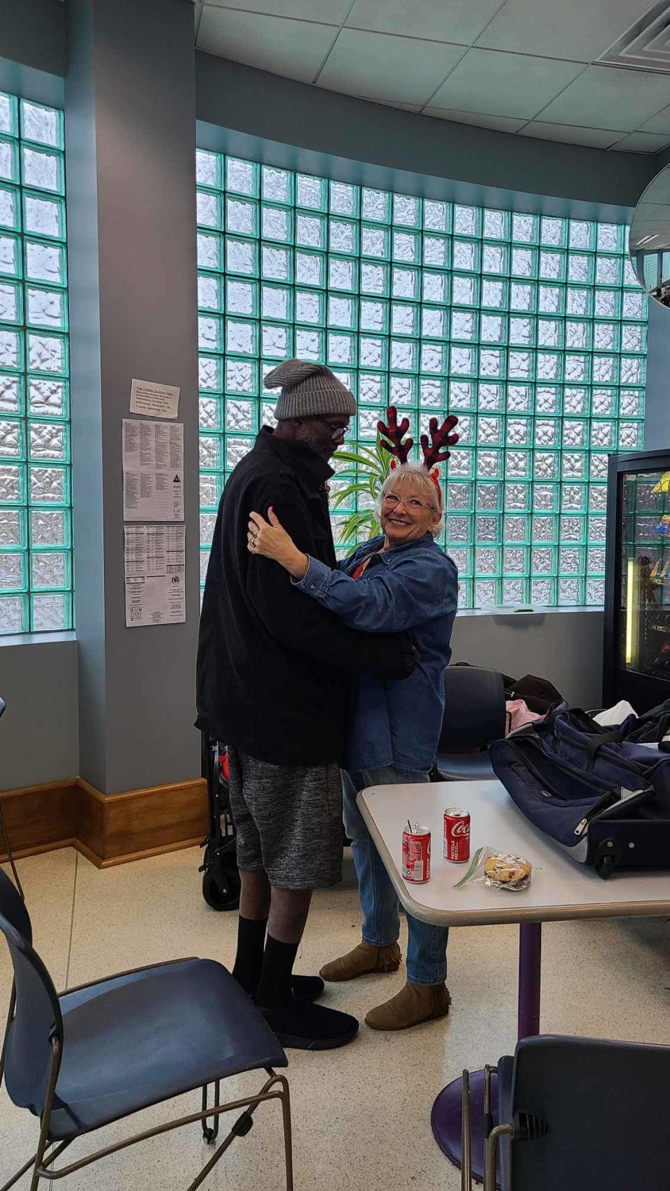 Robin Ann Carter hugs one of the homeless men who attended a Christmas party put on by Warm for the Winter also known as the Wagon Train Warriors. The group feeds homeless people every week.