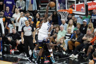Minnesota Timberwolves guard Anthony Edwards (5) gets past the Phoenix Suns defense for a dunk during the second half of Game 4 of an NBA basketball first-round playoff series Sunday, April 28, 2024, in Phoenix. The Timberwolves won 122-116, taking the series 4-0. (AP Photo/Ross D. Franklin)