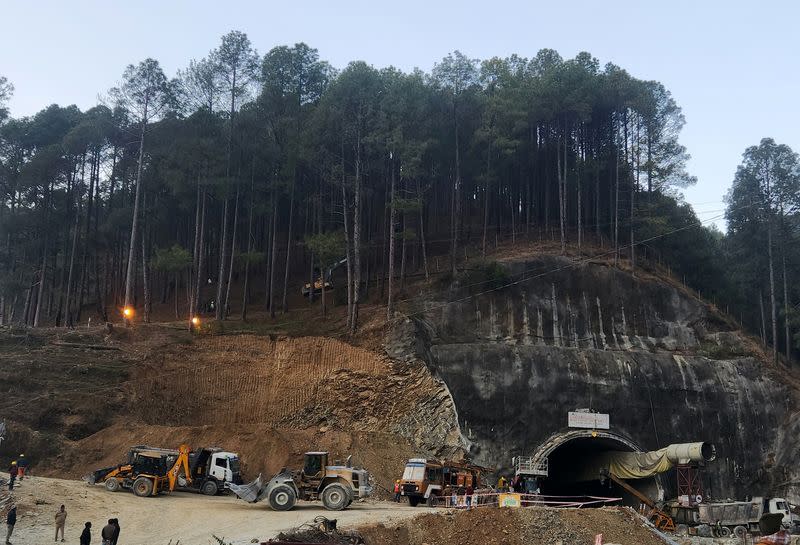 Rescuers use a digger to make a path at the top of the mountain as part of an alternate plan to reach the workers trapped in a tunnel, in Uttarkashi