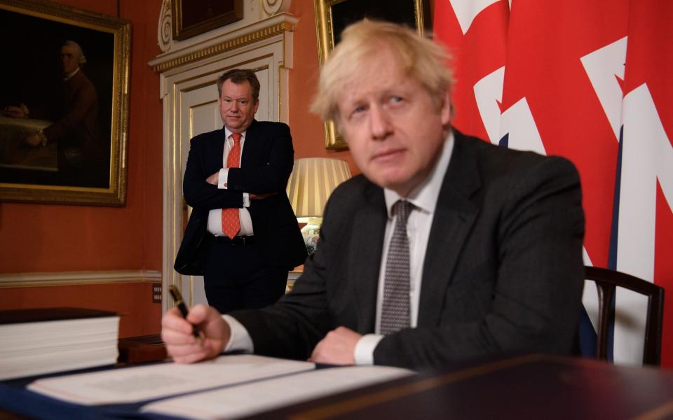  UK chief trade negotiator, David Frost (L) looks on as Britain's Prime Minister Boris Johnson (R) signs the Trade and Cooperation Agreement between the UK and the EU - LEON NEAL/POOL/AFP via Getty Images