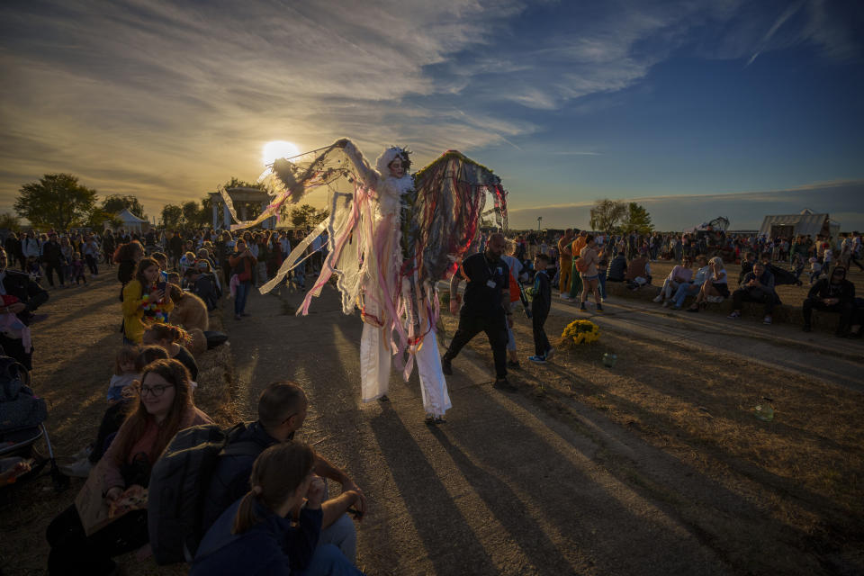 An entertainer on stilts walks among participants at the West Side Hallo Fest, a Halloween festival in Bucharest, Romania, Saturday, Oct. 28, 2023. Tens of thousands streamed last weekend to Bucharest's Angels' Island peninsula for what was the biggest Halloween festival in the Eastern European nation since the fall of Communism. (AP Photo/Andreea Alexandru)