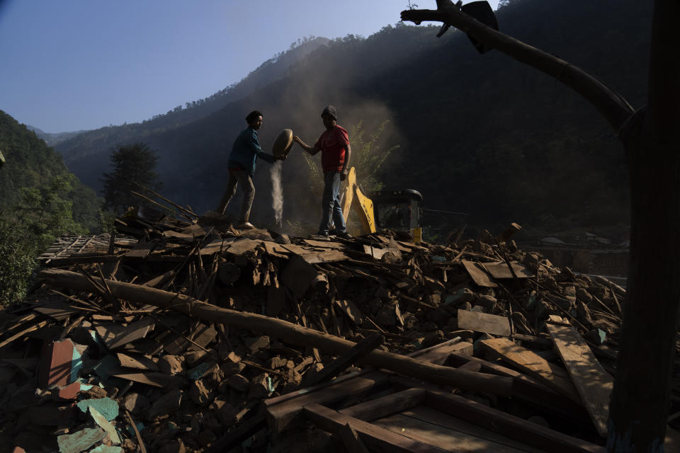 Survivors clear debris as they try to recover goods from earthquake damaged houses in Rukum District, northwestern Nepal, Monday, Nov. 6, 2023. The Friday night earthquake killed more than 150 people and left thousands homeless. (AP Photo/Niranjan Shrestha)