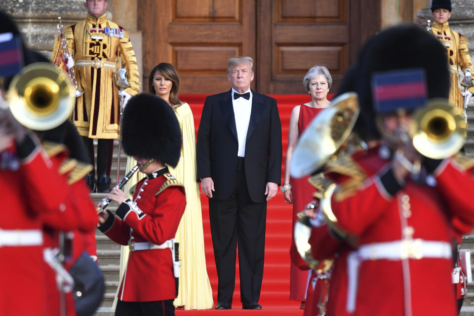 <p>Britain’s Prime Minister Theresa May, right, stands with President Donald Trump, centre, and first lady Melania Trump on the steps of the Great Court as the bands of the Scots, Irish and Welsh Guards perform a ceremonial welcome, as they arrive for a black-tie dinner at Blenheim Palace, at Blenheim, west of London, Thursday July 12, 2018. (Photo: Ben Stansall / Pool via AP) </p>
