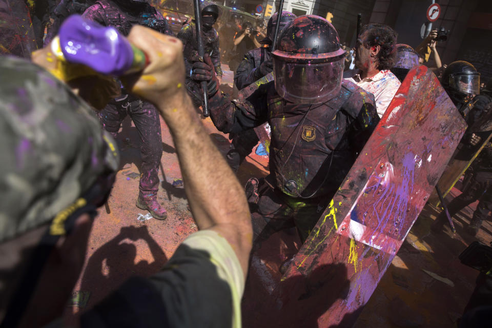 Catalan police officers clash with pro-independence demonstrators on their way to meet demonstrations by member and supporters of National Police and Guardia Civil in Barcelona on Saturday, Sept. 29, 2018. (AP Photo/Emilio Morenatti)