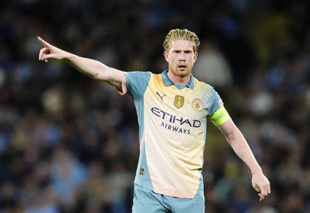 Kevin De Bruyne, wearing Manchester City's cream European kit, points during a game