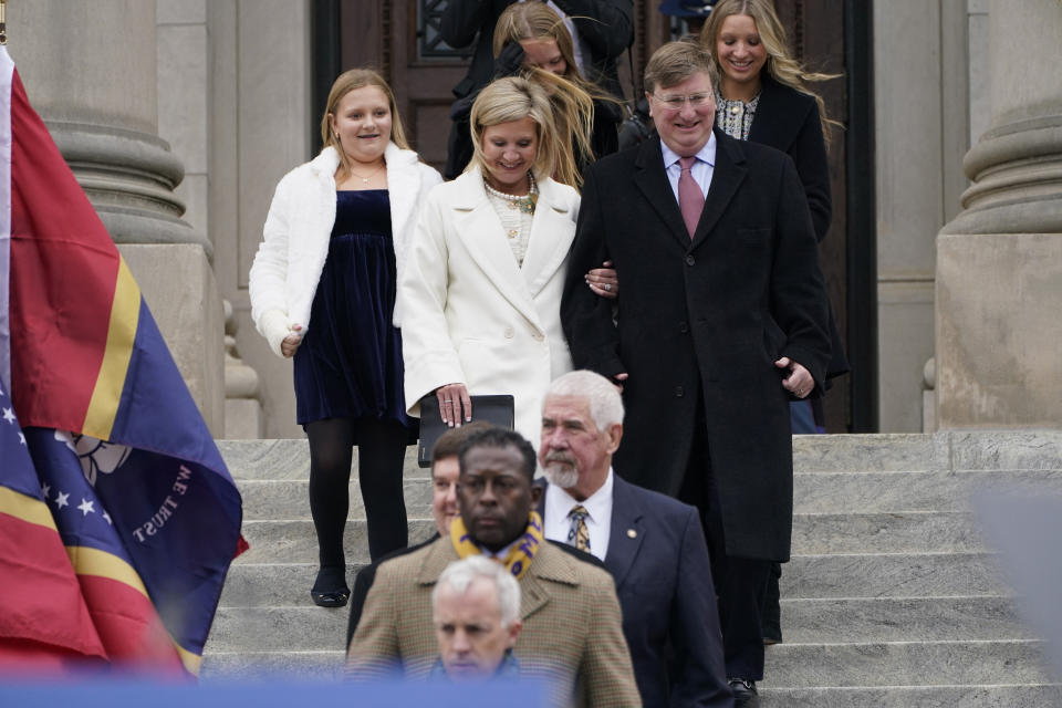 Following an escort line of legislators, Mississippi Republican Gov. Tate Reeves, right, and wife Elee Reeves lead their family down the steps of the Mississippi State Capitol for the start of Reeves' second term inauguration in Jackson, Miss., Tuesday, Jan. 9, 2024. (AP Photo/Rogelio V. Solis)