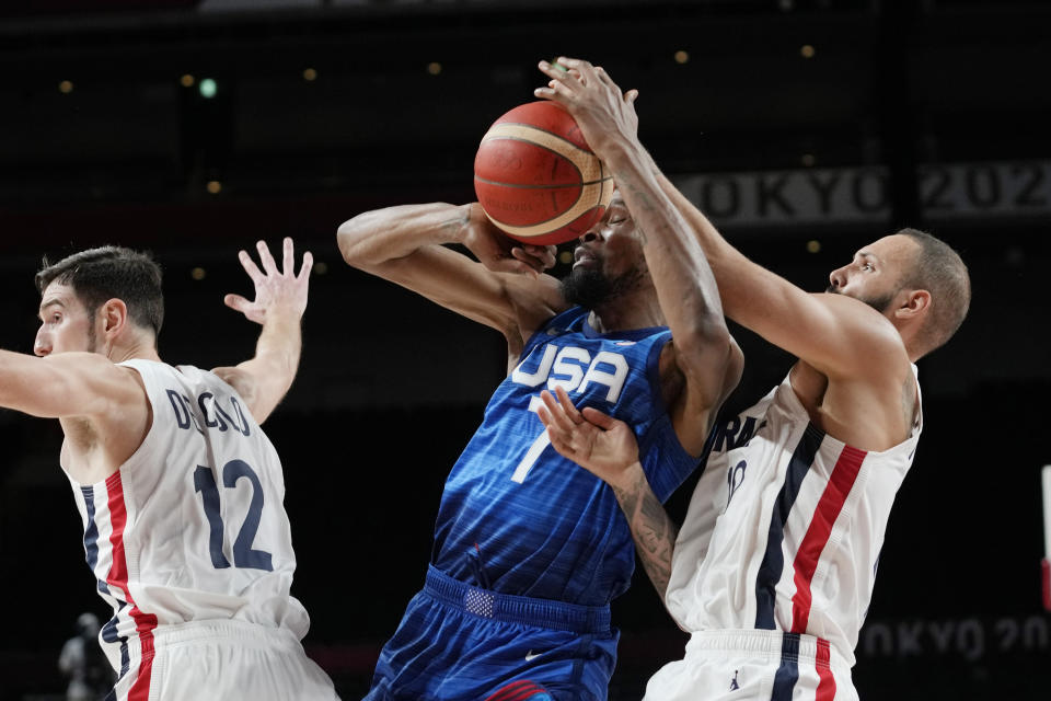 United States' forward Kevin Durant (7) and France's Evan Fournier, right, fight for control of the ball during a men's basketball preliminary round game at the 2020 Summer Olympics, Sunday, July 25, 2021, in Saitama, Japan. (AP Photo/Eric Gay)