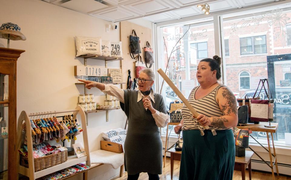 Sarah Bertochi, left, and Hudson artist Stephanie Krist discuss where to hang an abstract painting at Sarah Bertochi-Handmade at 63A Main St. in downtown Hudson, March 23, 2023.