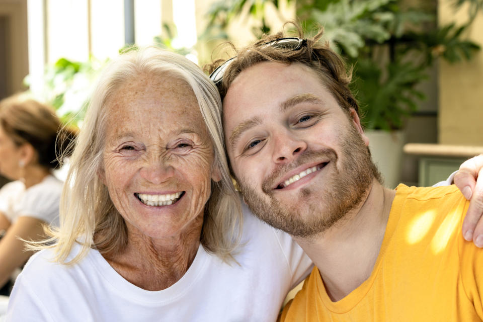 Portrait of happy grandmother and her adult grandson as inflation remains high.