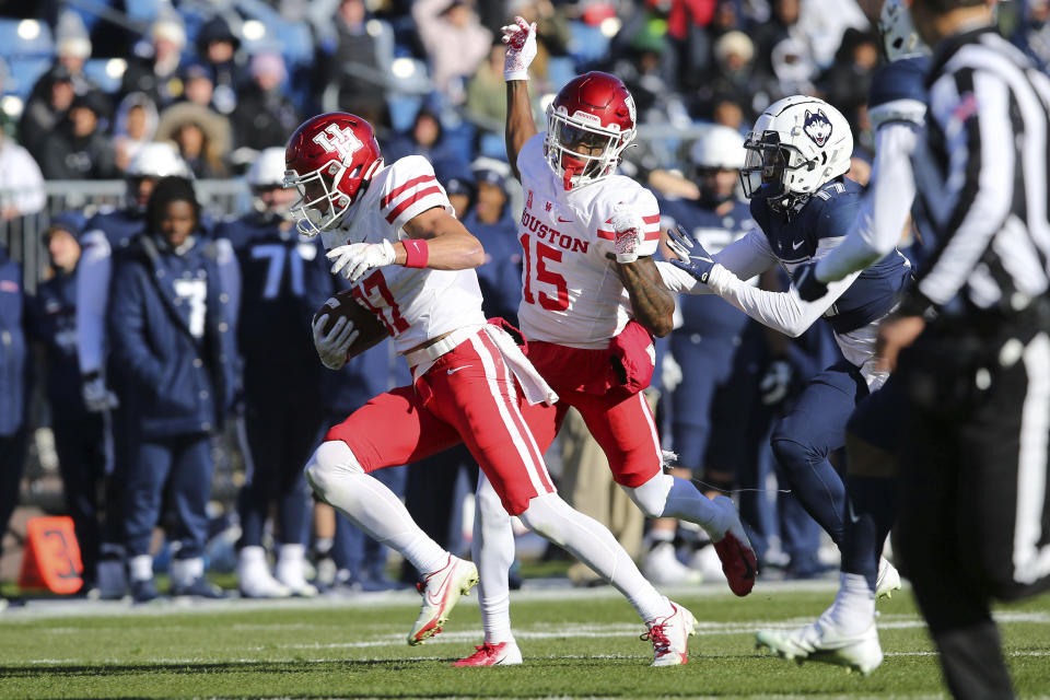 Houston wide receiver Jake Herslow (87) runs for a touchdown after a reception as wide receiver Jaylen Erwin (15) blocks Connecticut defensive back Stan Cross (17) during the first half of an NCAA football game, Saturday, Nov. 27, 2021, in East Hartford, Conn. (AP Photo/Stew Milne)