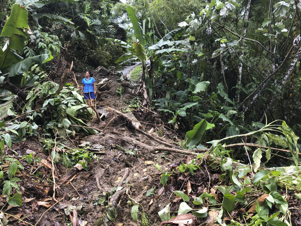 Nancy Galarza observa los daños en su comunidad en Caguas, Puerto Rico, el jueves 22 de septiembre de 2022, la cual seguía aislada cuatro días después del paso del huracán Fiona. (AP Foto/Danica Coto)