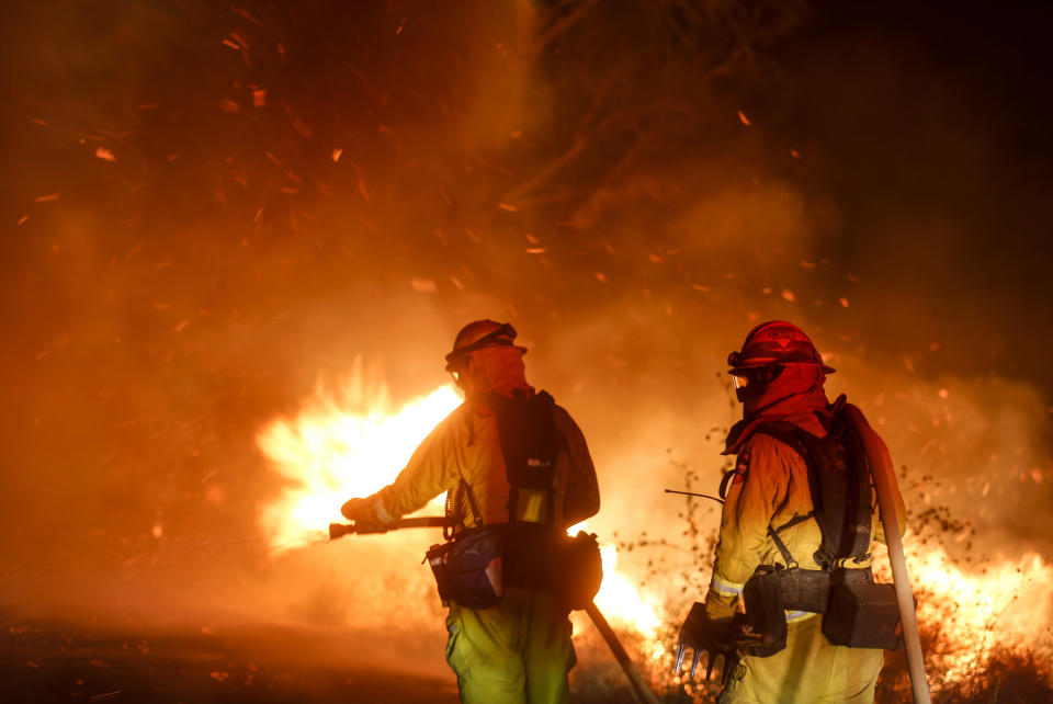 Firefighters battle a wildfire in Riverside, Calif. Thursday, Oct. 31, 2019. Santa Ana winds are expected to linger for a final day after driving more than a dozen wildfires through California. (AP Photo/Ringo H.W. Chiu)