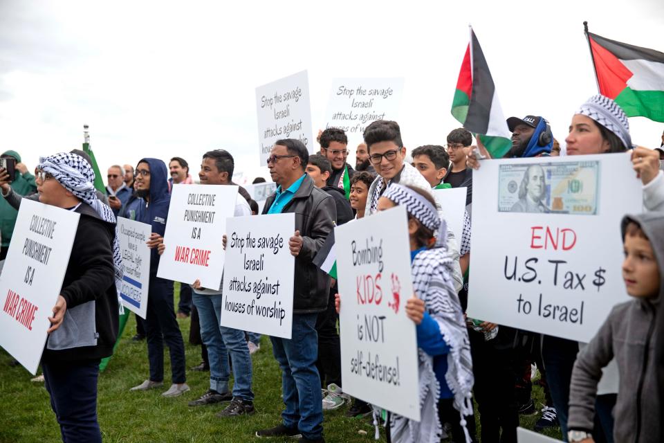 People hold up signs and flags to show their support for Palestinians on Tuesday, Oct. 10, 2023, at the Islamic Society of Milwaukee.