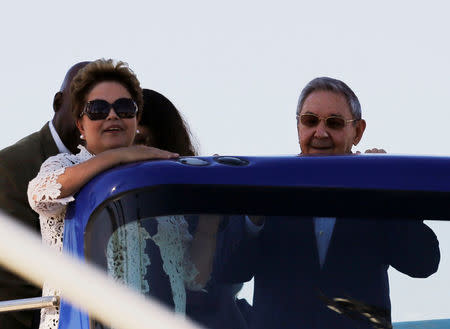 Brazil's President Dilma Rousseff (L) and her Cuban counterpart Raul Castro stand aboard a tour bus during the inauguration of a port in Mariel on the outskirts of Havana in this January 27, 2014 file photo. REUTERS/Claudia Daut/File Photo