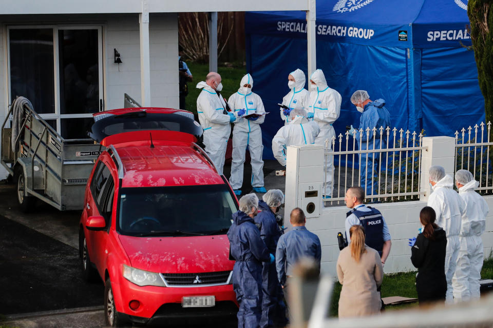 New Zealand police investigators work at a scene in Auckland on Aug. 11, 2022, after bodies were discovered in suitcases.