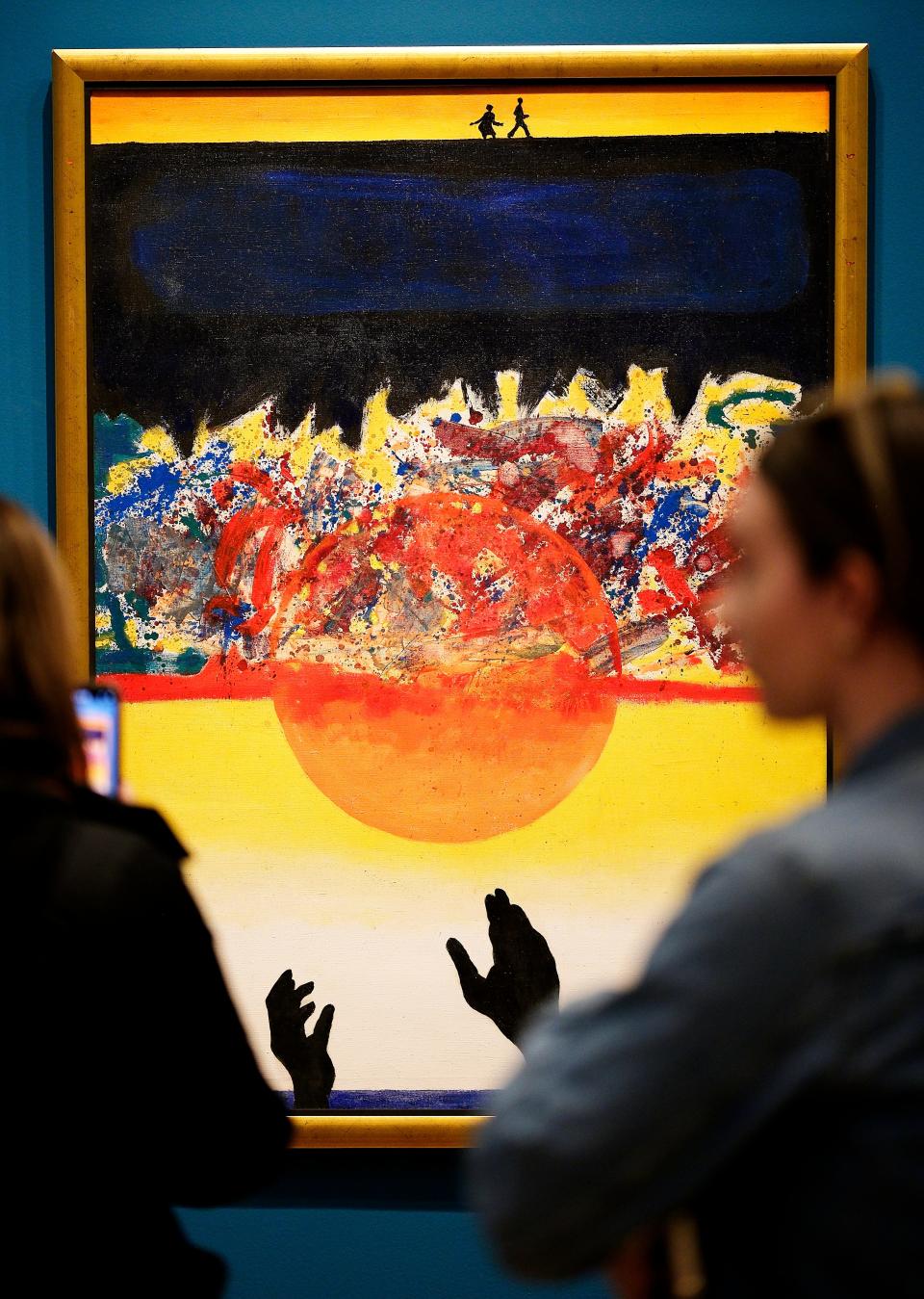 Visitors look at David C. Driskell's 1972 acrylic on canvas painting "Swing Low, Sweet Chariot" during a media tour of the special exhibition “Art and Activism at Tougaloo College" at the Oklahoma City Museum of Art on Thursday, February 16, 2023.