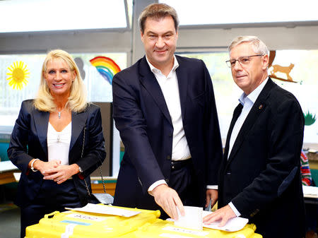 Markus Soeder, top candidate of the Christian Social Union Party (CSU), and his wife Karin Baumueller, cast their vote for the Bavarian state election in Nuremberg, Germany, October 14, 2018. REUTERS/Wolfgang Rattay