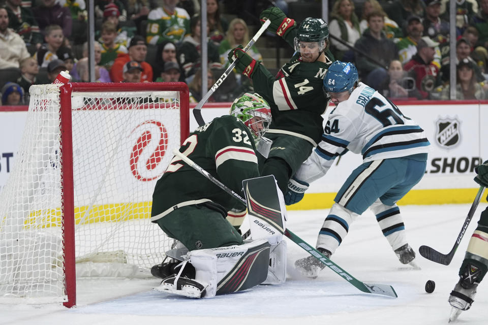 Minnesota Wild goaltender Filip Gustavsson (32) and center Joel Eriksson Ek (14) defend the goal against San Jose Sharks center Mikael Granlund (64) during the second period of an NHL hockey game Thursday, March 28, 2024, in St. Paul, Minn. (AP Photo/Abbie Parr)