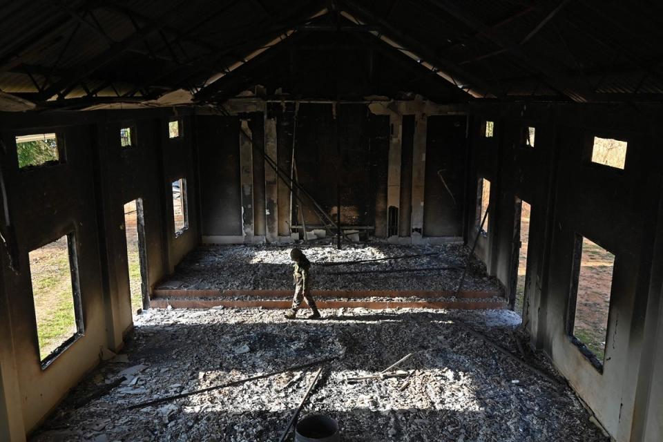 An Indian army soldier inspects the debris of a ransacked church that was set on fire by a mob in the ethnic violence hit area of Heiroklian village on 8 May (AFP via Getty Images)