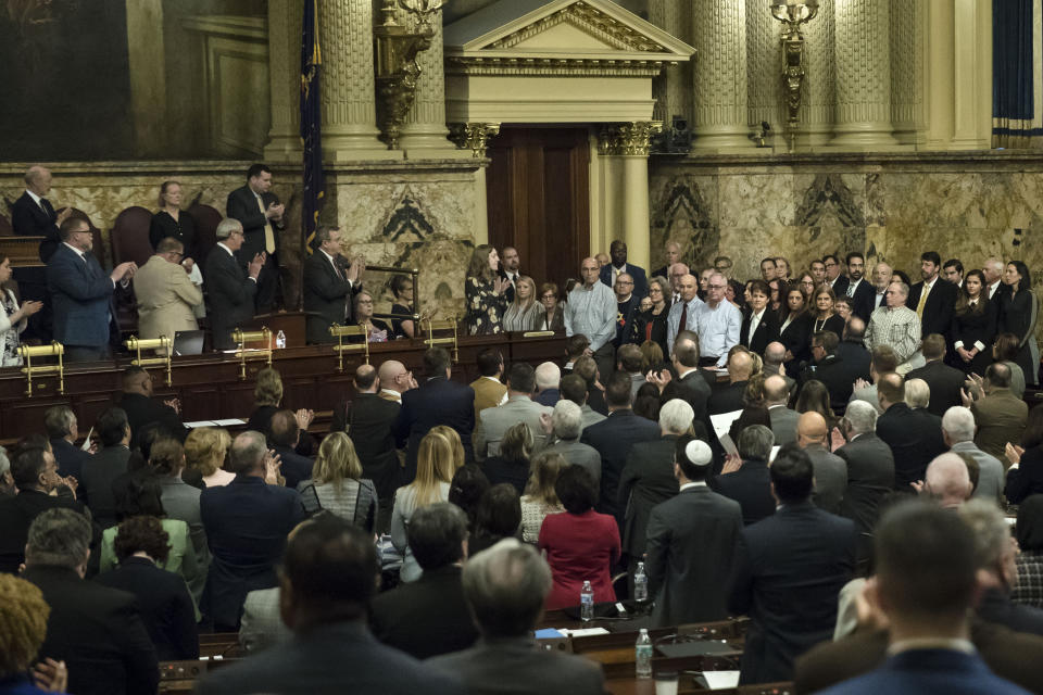 Guests, standing on the right, are acknowledged by Pennsylvania lawmakers who came together in an unusual joint session to commemorate the victims of the Pittsburgh synagogue attack that killed 11 people last year, Wednesday, April 10, 2019, at the state Capitol in Harrisburg, Pa. (AP Photo/Matt Rourke)
