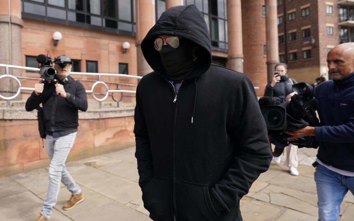 Adam Carruthers, who is charged for felling Sycamore Gap tree last year, arrives at Newcastle Crown Court alone wearing a black mask and sunglasses