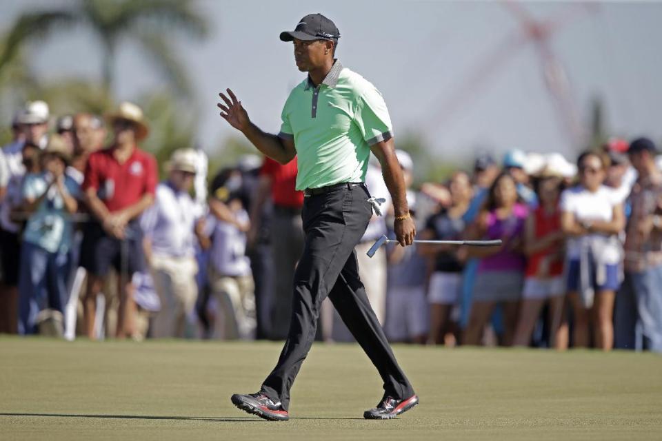 Tiger Woods acknowledges the gallery after making par on the 17th hole during the third round of the Cadillac Championship golf tournament Saturday, March 8, 2014, in Doral, Fla. (AP Photo/Wilfredo Lee)